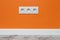 White triple outlet on orange wall