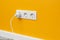 White triple outlet on yellow wall