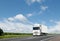 White truck on country highway under blue sky