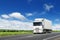 White truck on country highway under blue sky