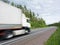 White truck speeding on rural highway, motion blur