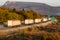 White trucks in convoy on a highway going away