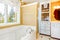 White tub and yellow walls. Bathrom interior.