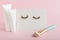 White tubes with mock up for design. False eyelashes, makeup brush on pink background. Beauty products, cosmetics for eyes makeup