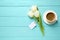 White tulips, coffee and blank tag on blue wooden table, flat lay with space for text. Good morning