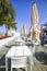 White umbrellas, tables and chairs in summer cafe.