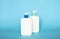 White unbranded bottles with a dispenser isolated on blue background. cosmetic packaging mockup with copy space. Bottle