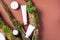 White unlabelled cosmetic bottle on brown background, natural moss over branches, bark. Skin care, organic body