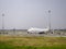 The white Unrecognizable plane at the airport takes passengers through a telescopic ladder