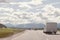 White van camping car on highway sunny cloudy sky background. Camper on the road.