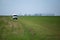 White van drive alone on a grass field on a sunny summer day