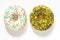 White vanila and yellow banana frosted donuts with colorful sprinkles  on white background