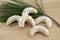 White vanilla crescents rolls delicious cookies with sugar icing on wood table, pine green branch needles, hazelnut pastry