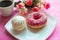 White vanilla zefir and pink donut on white plate, pink glitter background