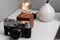 A white vase with a branch, old-fashioned lamp and an ancient camera