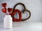 White vase filled with red glitter hearts sticking up with a red sparkly heart wreath and wooden heart wreath in the background on