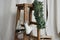 White vintage ice skates hanging on wooden stool, evergreen wreath and fabric background. Christmas interior decorations