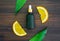 White vitamin c bottle and oil made from orange fruit extract, mockup of beauty product brand. Top view on the wood background.