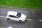 White Volkswagen Golf car in a strong thunderstorm with a heavy rain. Dangerous driving conditions and aquaplanning risk