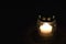 White votive candle on dark background. Burning grave candle