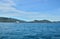 White walking catamaran in the sea, near the coastline of the island, against a background of sushi covered with