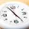 White wall clock with black arrows. Selective focus. Shallow depth of field. Toned