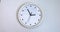 A white wall clock, isolated over white background. Clock time ticking. Time lapse 60 minutes moving fast. Time concept