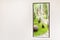 White wall with open door pass to beautiful green forest or park. Entrance to nature concept