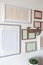 White wall with set of different empty vertical and horizontal frames to create family photo gallery