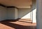 White wall, terracotta tiled floor and columns in the entrance of a residential building. Oblique shadow divides the scene.