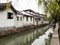 White walled houses reflected in canal waters in historic downtown Suzhou