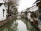 White walled houses reflected in canal waters in historic downtown Suzhou