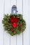 White-washed walls of wood barn with lantern and large holiday wreath at Christmas time