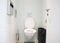 White water closet, restaurant bathroom, small toilet room with a wall mounted, wall hung ceramic toilet bowl, toilet brush, waste