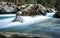 White Water Rushes Around Lichen Coverd Boulders