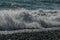 White wave breaking on Sochi Black Sea coast. White spray and foam in the foreground. Emerald blue sea water beyond.