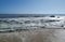 White waves breaking on sandy beach in summer. Straight on view.