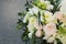 White Wedding Bouquet Roses Pink flowers and Ruscus Leaves with Robbons on Gray Asphalt Background. Wedding Decoration