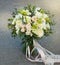 White Wedding Bouquet Roses Pink flowers and Ruscus Leaves with Robbons on Gray Asphalt Background. Wedding Decoration. Square Ima