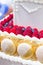 White wedding cake decorated with golden macaroons and berries - raspberries, blueberries, Close up