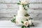 White wedding cake with floral decorations on white background