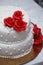 White wedding cake with red roses and beads