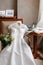 White wedding dress with lace lying on the chair. bouquet different flowers. Modern bridal bunch with poppy flower and