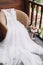 White wedding dress lying on armchair on wooden balcony with beautiful landscape. Bride`s morning