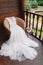 White wedding dress lying on armchair on wooden balcony with beautiful landscape. Bride`s morning.Wedding bouquet