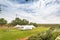 White wedding tent outside with blue sky and green grass