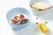 white wheat and chocolate granola with low-fat yogurt in a white bowl in a composition with a spoon, honeycombs, banana fig on