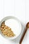 white wheat granola with low-fat yogurt in a white bowl in a composition with a spoon on white wooden background. Healthy