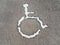 White wheelchair or handicapped symbol on asphalt