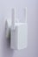 White wi-fi range extender plugged in electrical socket